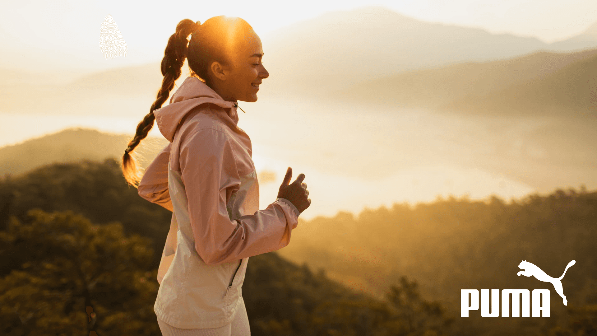 Happy young woman running outdoors with mountain view at sunset