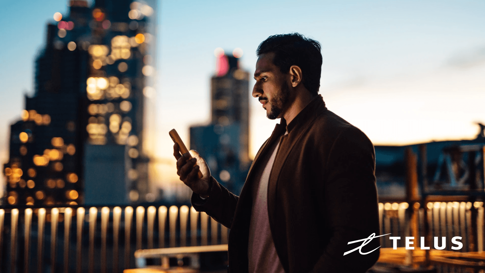 A businessman uses a mobile phone on a rooftop